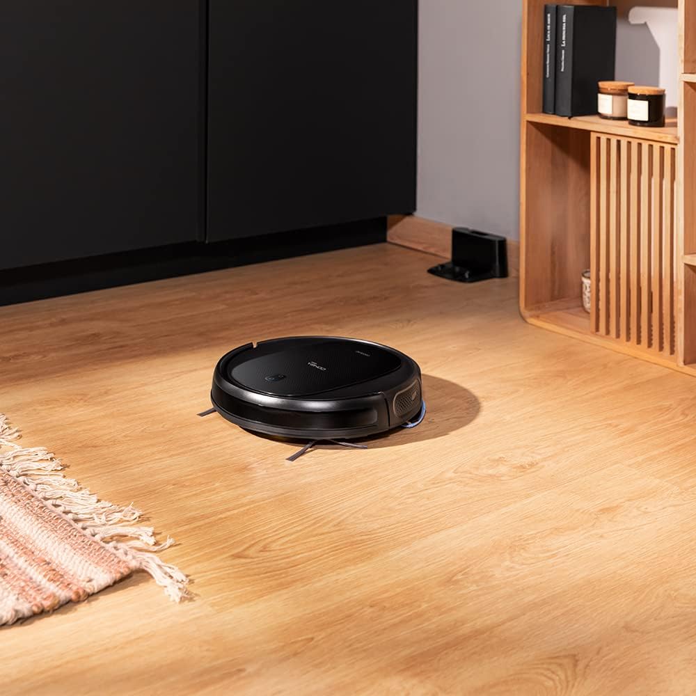 Robot aspirador Conga 999 Titanium limpiando una sala de estar con suelo de madera.